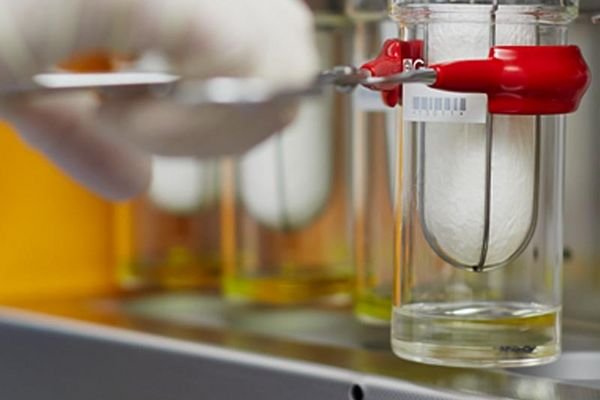 A laboratory setup showing Soxhlet extraction for food analysis using a cellulose thimble